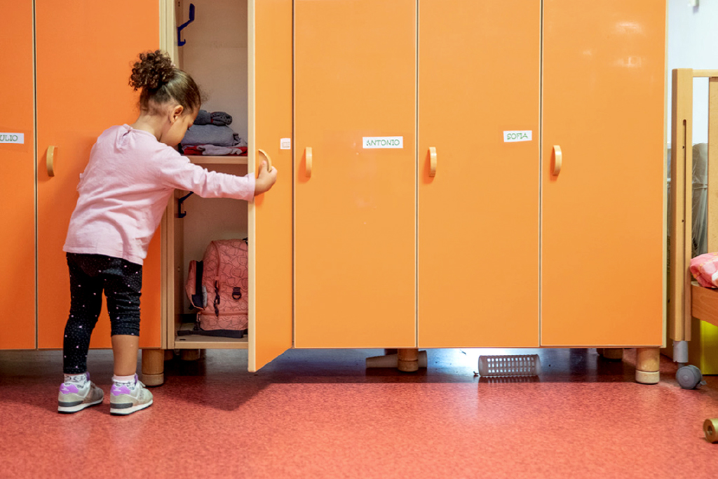 Bambina all'armadietto dell'asilo nido