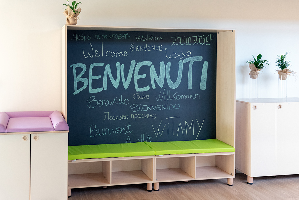 Entrata con Benevenuti scritto in diverse lingue sulla lavagna
